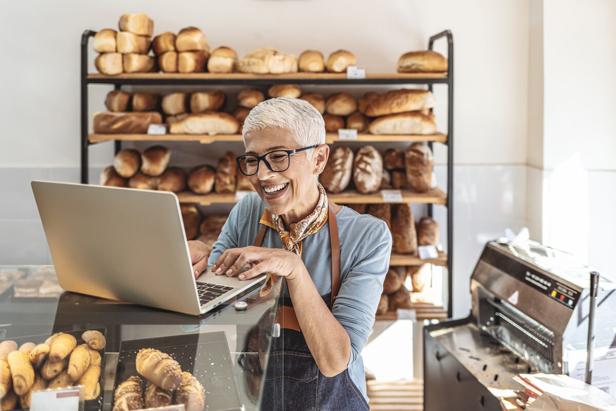 Baker using laptop in her bakery