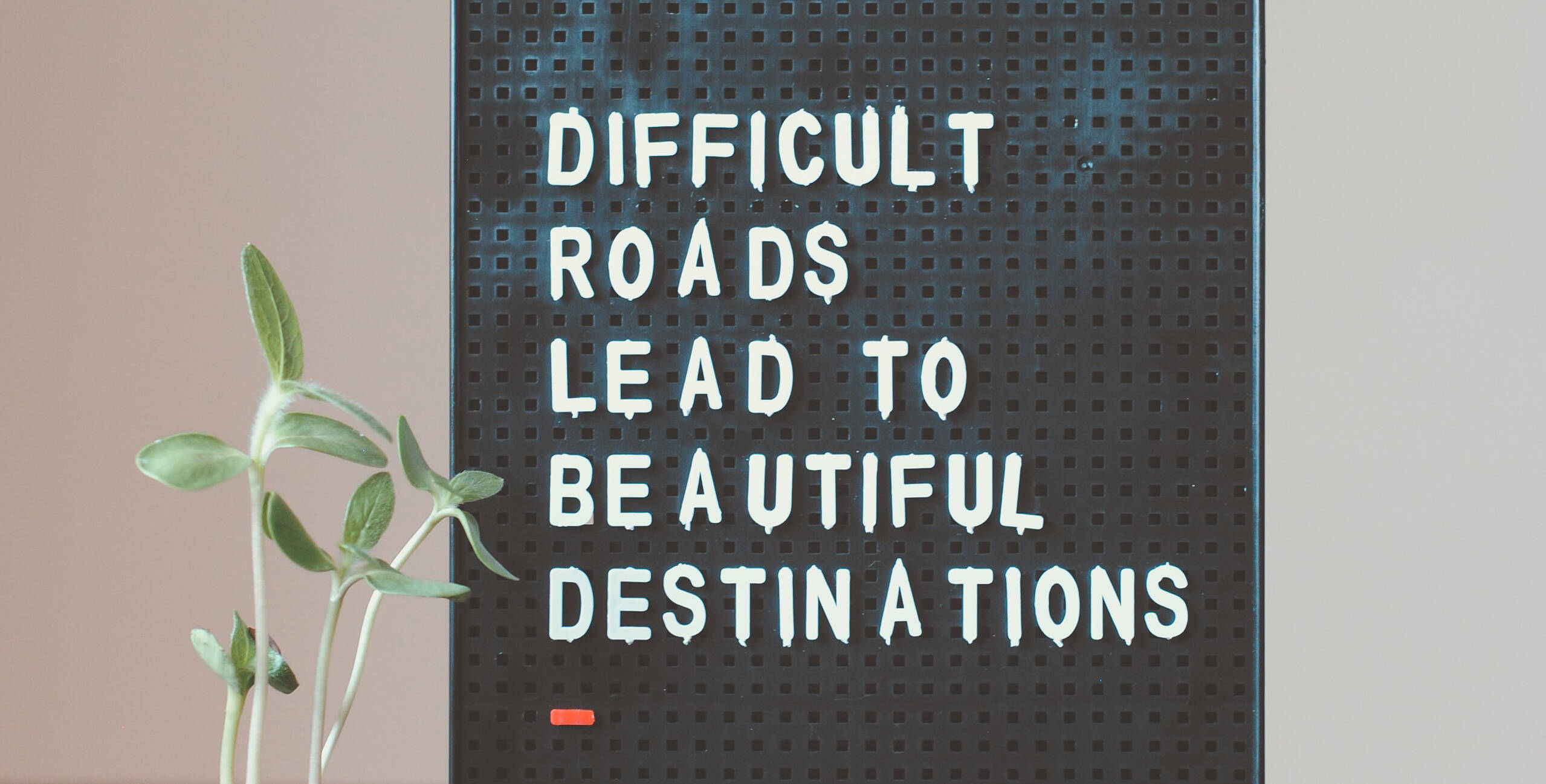 Clipboard with "Difficult roads lead to beautiful destinations" text