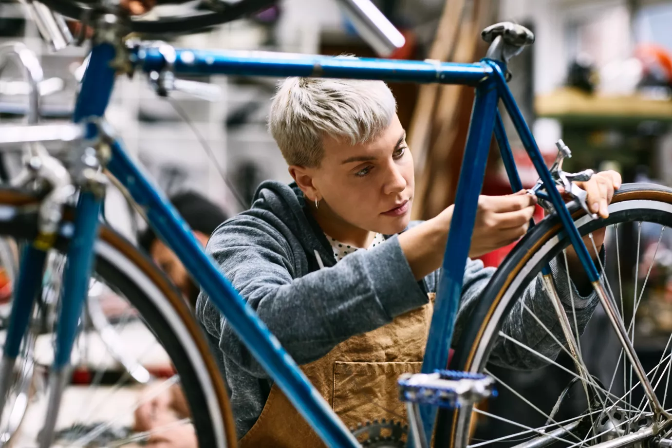 Small business owner thinking about how to improve cashflow while fixing a customers bike